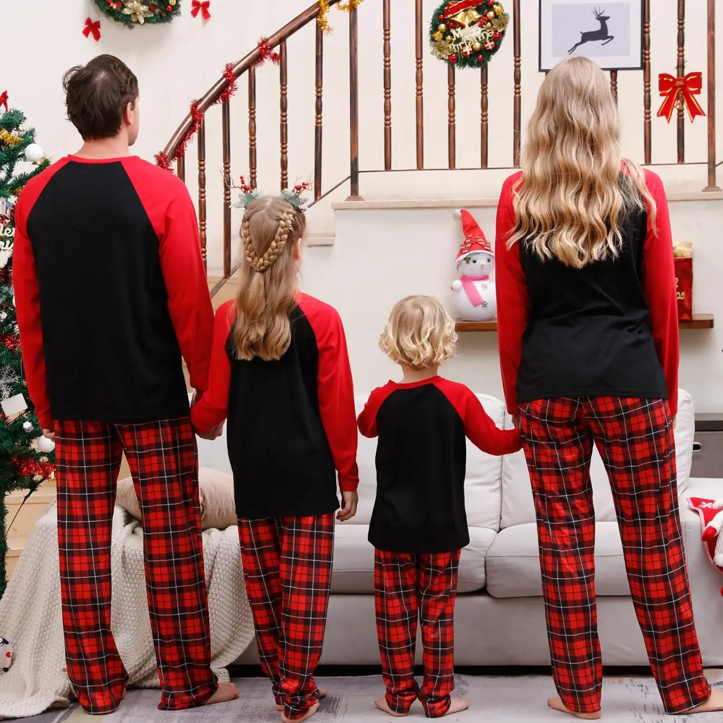 Family wearing matching Christmas pyjamas around the tree