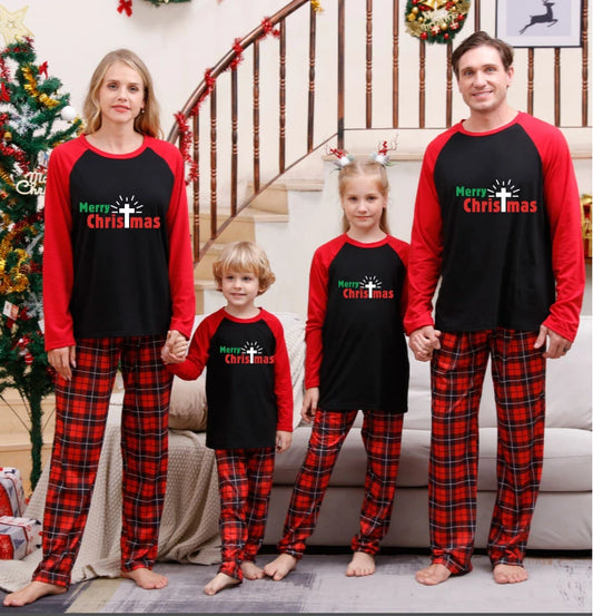 Family wearing matching Christmas pyjamas around the tree